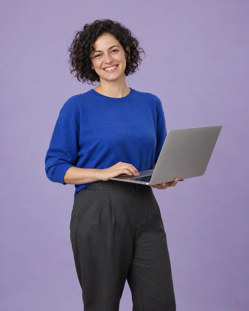 Una emprendedora sonríe mientras sostiene un portátil.